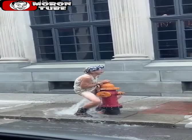 Video :An elderly woman finds comfort in the fire hydrant's jet